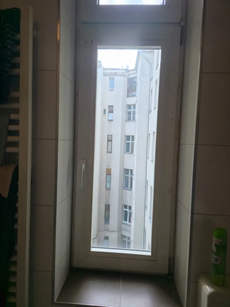 Hohes schmales Kunststofffenster in einem Altbau-Badezimmer